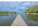 Scenic lake view with a wooden dock stretching into calm waters under a blue sky at 12405 Stonelake Ranch Blvd, Thonotosassa, FL 33592