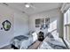 Well-lit bedroom featuring two twin beds, a ceiling fan, and large windows at 12940 Brookside Moss Dr, Riverview, FL 33579