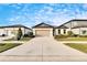 Charming one-story house with a two-car garage, neat lawn, and a welcoming front porch at 12940 Brookside Moss Dr, Riverview, FL 33579