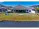 House with screened patio, white fence, and lush lawn by lake at 13614 Tonya Anne Dr, Riverview, FL 33579