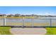 White vinyl fence encloses grassy backyard with paver patio and lake view at 13614 Tonya Anne Dr, Riverview, FL 33579