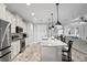 Modern kitchen with white cabinets, granite island and stainless steel appliances at 13614 Tonya Anne Dr, Riverview, FL 33579