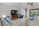 Bright living room featuring a large TV and sliding doors to patio at 13614 Tonya Anne Dr, Riverview, FL 33579