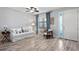 Bright living room with white couch, wood floors, and a ceiling fan at 13614 Tonya Anne Dr, Riverview, FL 33579