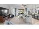 Open living space with grey sectional sofa and view of kitchen and patio at 13614 Tonya Anne Dr, Riverview, FL 33579