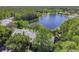 Aerial view of condo buildings nestled amongst green trees near a lake at 1433 Pine Glen Pl # D1, Tarpon Springs, FL 34688