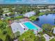 Aerial view of community pool, tennis courts, and lush landscaping at 1433 Pine Glen Pl # D1, Tarpon Springs, FL 34688