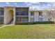 Two-story condo building with screened balconies and landscaping at 1433 Pine Glen Pl # D1, Tarpon Springs, FL 34688