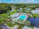 Aerial view of community pool, tennis court, and lake at 1433 Pine Glen Pl # D1, Tarpon Springs, FL 34688