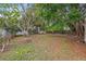 Large backyard with mature trees and a partially grassy area at 150 Almedo Ne Way, St Petersburg, FL 33704