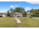 Tan single story home with a walkway and lawn at 150 Almedo Ne Way, St Petersburg, FL 33704