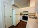 Galley kitchen with white cabinets and laminate flooring at 1568 Nantucket Ct # 1302, Palm Harbor, FL 34683