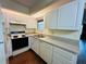 Kitchen with white cabinets, laminate flooring, and appliances at 1568 Nantucket Ct # 1302, Palm Harbor, FL 34683