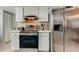 Stainless steel appliances and white cabinetry in kitchen at 16115 Country Crossing Dr, Tampa, FL 33624