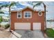 Two-story house with attached two-car garage, neutral color, and palm trees at 16134 4Th E St, Redington Beach, FL 33708