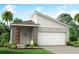 One-story home with modern design, gray exterior, orange door, and stone accents at 17777 Solstice Ave, Venice, FL 34293