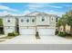Two-story townhome with attached two-car garage, landscaping, and neutral color palette at 1815 Sunset Wind Loop # 118, Oldsmar, FL 34677