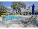 Community pool with lounge chairs and umbrellas at 1815 Sunset Wind Loop # 118, Oldsmar, FL 34677
