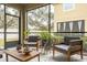 Bright screened porch with wooden chairs and a view of trees at 1815 Sunset Wind Loop # 118, Oldsmar, FL 34677