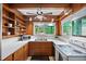 Retro kitchen features wood cabinets, updated appliances, and a window overlooking the backyard at 200 57Th S Ave, St Petersburg, FL 33705