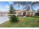 House exterior showcasing landscaping and a three-car garage at 2342 Edelweiss Loop, Trinity, FL 34655