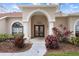 Elegant front entry with arched doorway, columns, and landscaping at 2342 Edelweiss Loop, Trinity, FL 34655