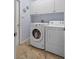 Bright laundry room with washer, dryer, and upper cabinets at 2342 Edelweiss Loop, Trinity, FL 34655