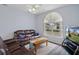 Bright living room with a comfy leather sofa, coffee table and large window at 2342 Edelweiss Loop, Trinity, FL 34655