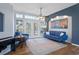 Living room with hardwood floors, blue sofa, and access to the pool at 2342 Edelweiss Loop, Trinity, FL 34655