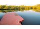 Red wooden dock extending over calm water, reflecting lush greenery at 4506 24Th S Ave, Tampa, FL 33619