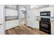 Kitchen with white cabinets, granite countertops, and black appliances at 5301 Watson Rd, Riverview, FL 33578
