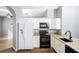 Kitchen boasts white cabinets, granite countertops, and black appliances at 5301 Watson Rd, Riverview, FL 33578