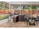 Outdoor kitchen with sink, cabinets, and dining area under a screened patio at 5301 Watson Rd, Riverview, FL 33578