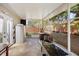 Spacious screened porch with a table, mini-fridge, and backyard access at 5301 Watson Rd, Riverview, FL 33578