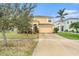 Two-story house with a tan exterior, two-car garage, and landscaping at 534 19Th Nw St, Ruskin, FL 33570