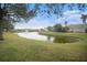 Serene pond view with lush green landscaping and neighborhood homes in the background at 534 19Th Nw St, Ruskin, FL 33570
