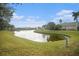 Calm pond view with surrounding lush grass and neighborhood homes at 534 19Th Nw St, Ruskin, FL 33570