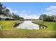 Scenic pond with grassy banks, providing a tranquil neighborhood view at 534 19Th Nw St, Ruskin, FL 33570