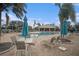 Community pool with tables, chairs, and umbrellas for shade at 534 19Th Nw St, Ruskin, FL 33570