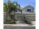 Tan two-story house with a two-car garage, and palm trees in front at 558 Harbor Ridge Dr, Palm Harbor, FL 34683