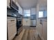 Modern kitchen with white cabinets, stainless steel appliances and gray tile backsplash at 5660 80Th N St # C307, St Petersburg, FL 33709