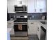 Modern kitchen with white cabinets, stainless steel appliances and gray tile backsplash at 5660 80Th N St # C307, St Petersburg, FL 33709
