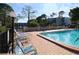 Inviting pool area with lounge chairs and a surrounding brick patio at 5660 80Th N St # C307, St Petersburg, FL 33709