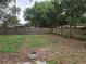 Large backyard with a fire pit and wooden fence at 5902 18Th St, Zephyrhills, FL 33542