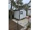 White storage shed with a ramp and small window at 5902 18Th St, Zephyrhills, FL 33542