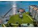 Aerial view of waterfront community with pier, lush landscaping, and resort-style amenities at 632 Edgewater Dr # 439, Dunedin, FL 34698