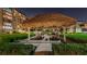 Covered picnic tables with grills under a thatched roof at night at 632 Edgewater Dr # 439, Dunedin, FL 34698