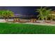 Two benches sit on a grassy area overlooking a calm body of water at night at 632 Edgewater Dr # 439, Dunedin, FL 34698