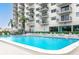 Community pool with surrounding lounge chairs and tables at 7050 Sunset S Dr # 211, South Pasadena, FL 33707