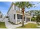 Two-story house with a walkway, palm tree, and gray garage door at 7714 S West Shore Blvd, Tampa, FL 33616